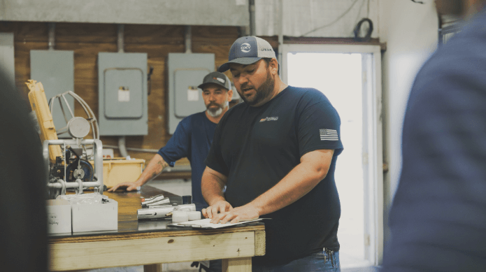 AllStream team members working with industrial equipment in the shop