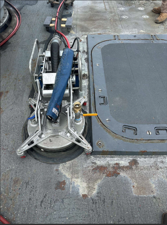 Robotic surface preparation equipment cleaning an industrial metal surface