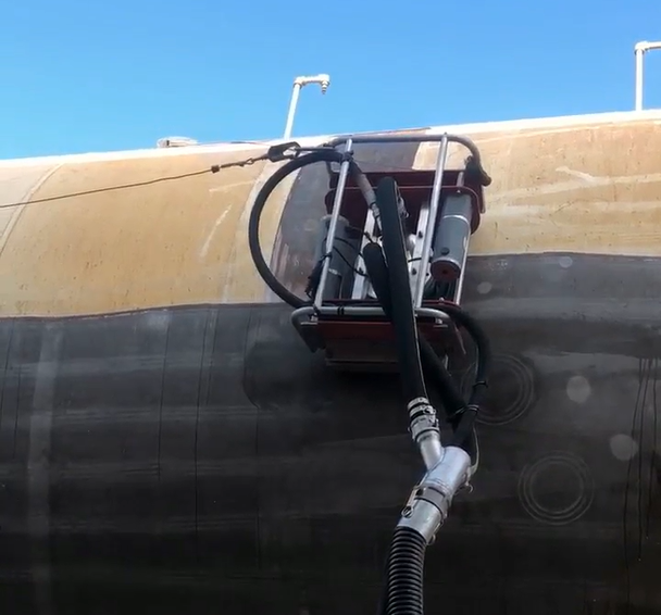 Robotic surface preparation equipment removing coatings from an industrial tank wall