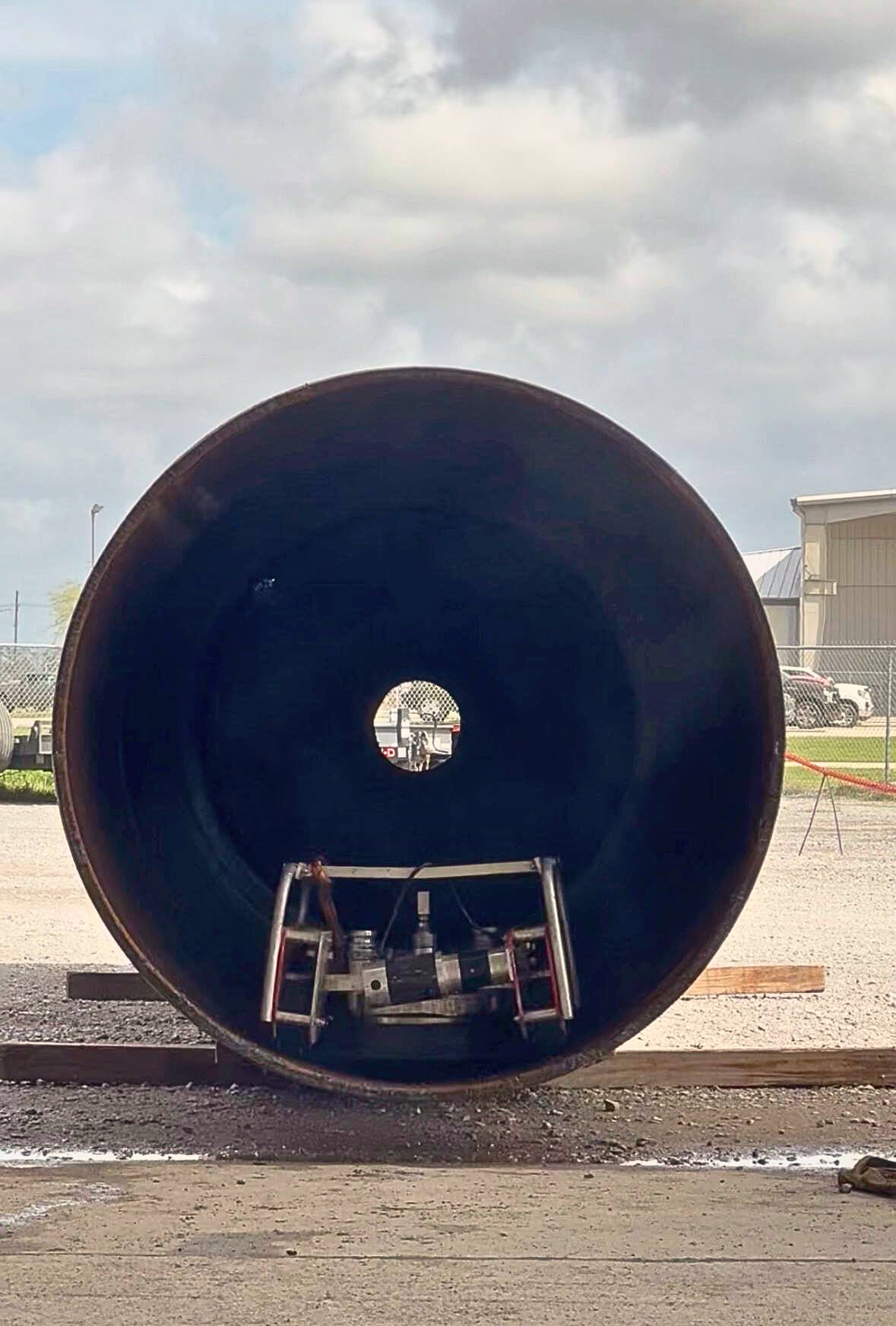 Robotic surface preparation equipment operating inside a large industrial pipe